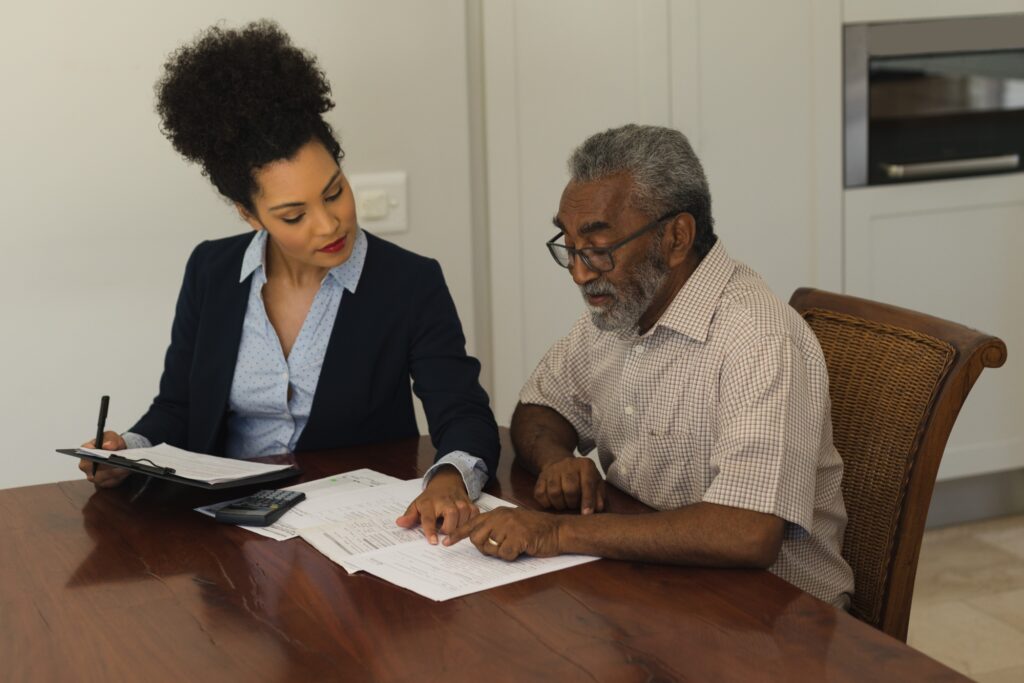 A real estate agent and senior man discussing the contract