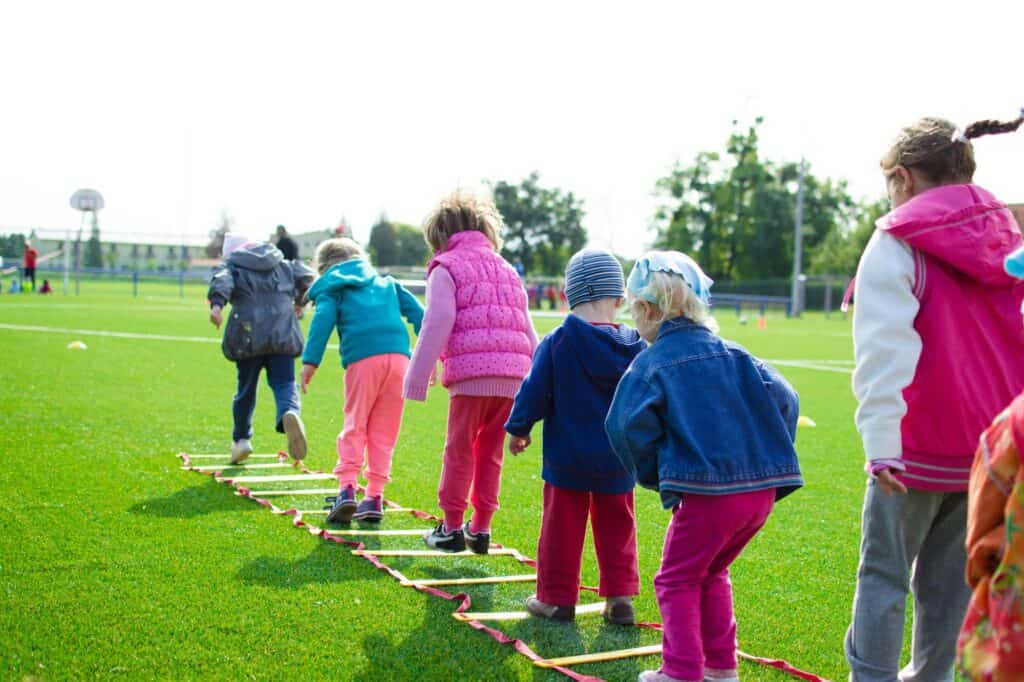 Children playing on a green field in the concept of services and amenities in Slough.