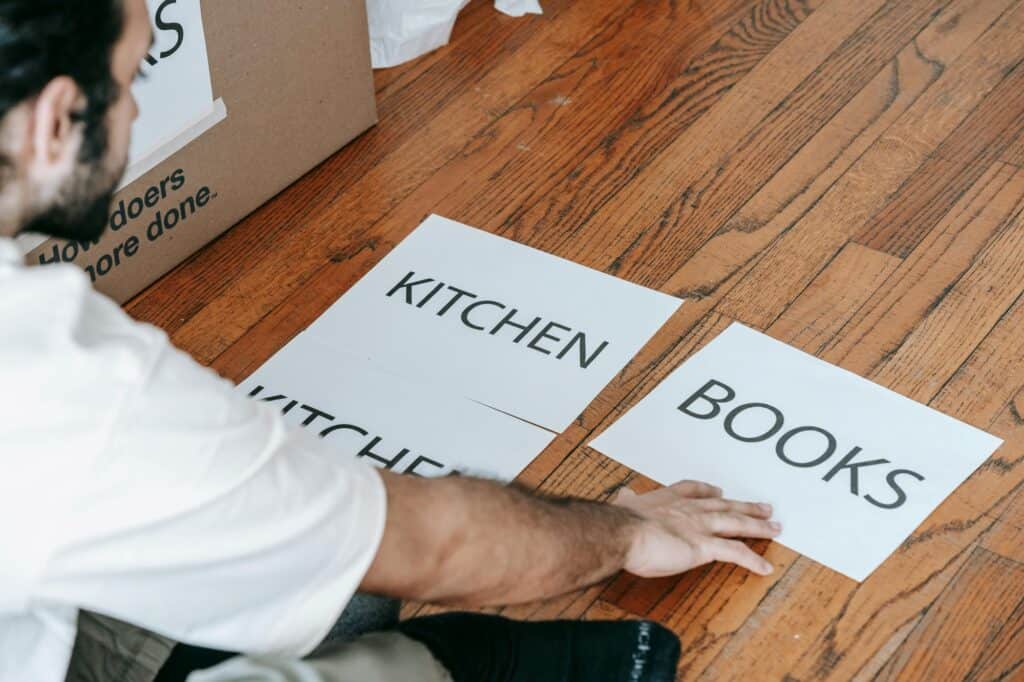 Professional mover picking up labels on the floor for moving boxes